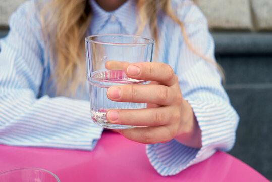 Woman holding glass with water