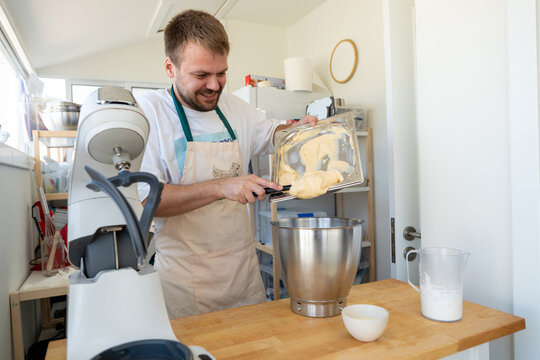 Baker Prepares Creamy Mixture in Modern Kitchen Setting