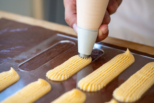 Piping Cream Into Molds for Exquisite Pastry Preparation