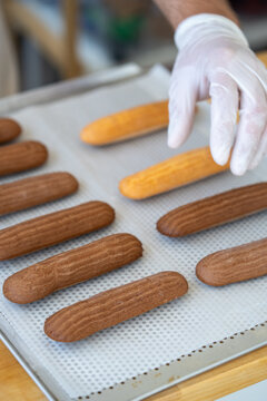 Baker Preparing Chocolate and Vanilla Eclairs in a Pastry Kitchen