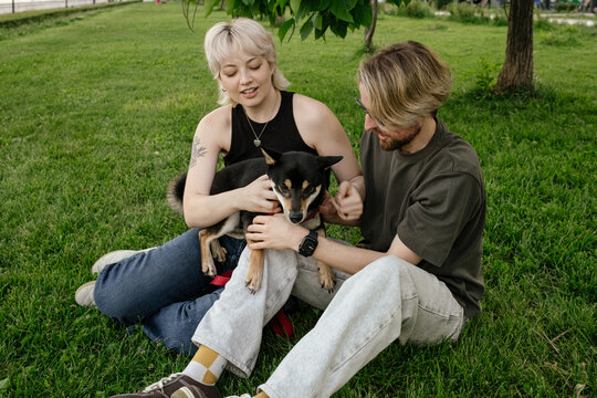 Pair Sharing a Calm Moment with dog  in the Park