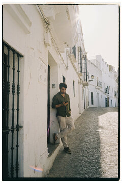 Man Leaning Using Phone