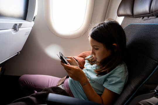 Young Girl Relaxing with ebook reading on Airplane