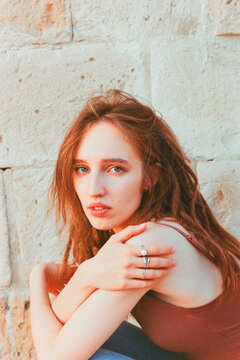 Young Woman Poses Thoughtfully Against a Textured Wall