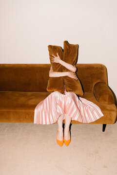 Person Hugging Pillows on Brown Couch