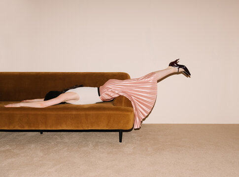 Person Relaxing on Cushioned Sofa