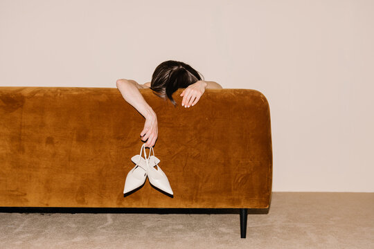 Person Reclining Behind a Sofa