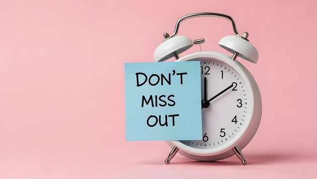 Vintage alarm clock with don't miss out note on pink background