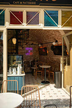 Istanbul, Turkey - October 8, 2026: View into a cozy coffee shop with brick vault ceiling, small tables and a neon sign reading &ldquo;Coffee is life&rdquo;, seen from the entrance with warm light in Balat
