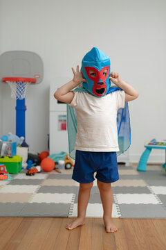 Toddler boy with cape and luchador mask.