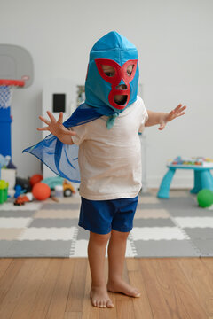 Toddler boy with cape and luchador mask.
