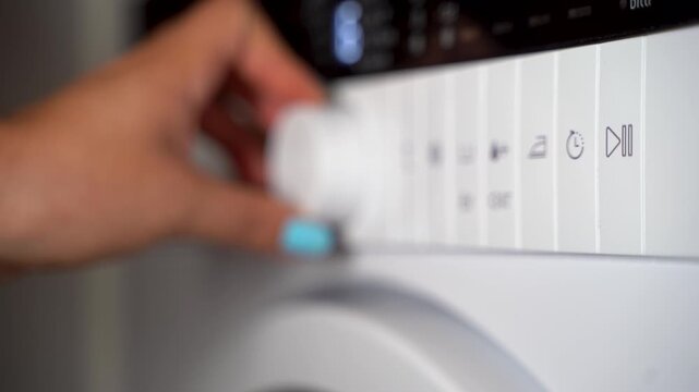 Young woman setting the washing machine