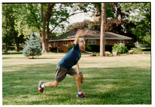 Child Playing Catch in a Sunny Backyard on a Summer Afternoon