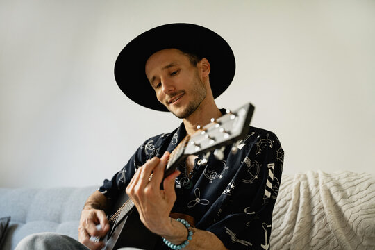 Singer sing sons and playing on guitar at home.