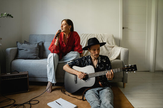 Couple musicians sing sons at home.