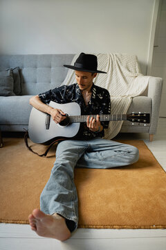 Singer sing sons and playing on guitar at home.