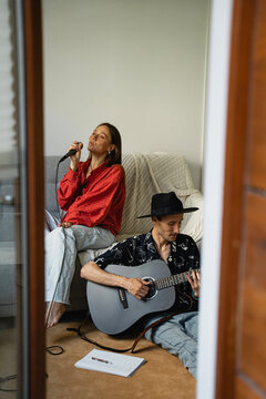Couple musicians sing sons at home.