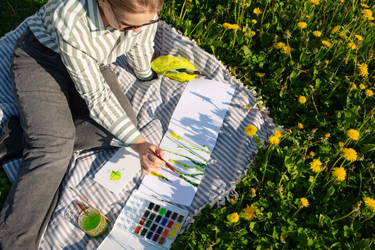 Artist creating watercolor painting in a blooming field