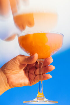 Drinking colorful mocktail / cocktail on blue background