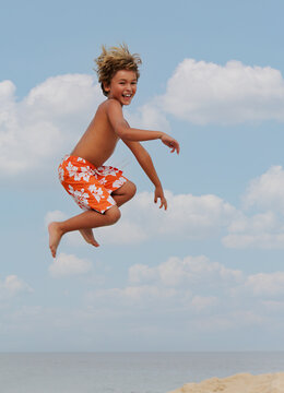 Boy jumps off a lifeguard chair