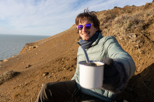 Enjoying a mate on a sandy beach at sunset