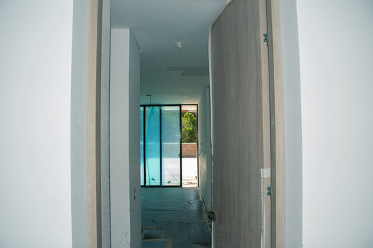 Renovation progress in modern hallway leading to outdoor space