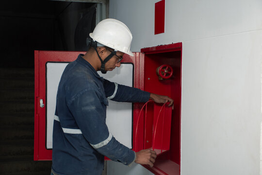 Worker checks fire safety equipment in a building