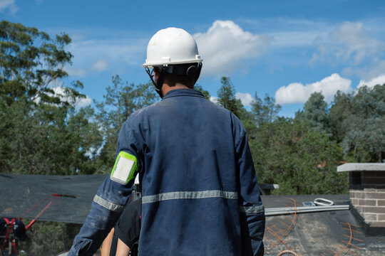 Worker in a safety helmet at a construction site under blue sky