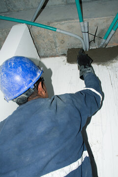 Construction worker applying cement during interior work