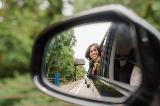 A woman looks out of a car window