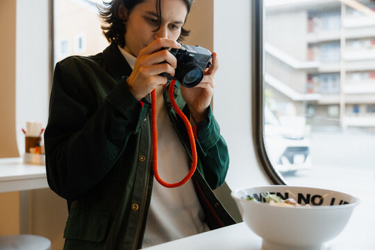 A woman takes pictures of food