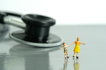 Obraz premium Miniature people toy figure photography. Fun medical checkup concept. Kids with stethoscope