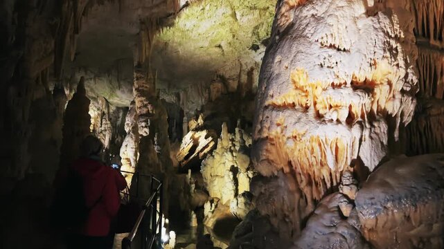 Stunning formations of stalagmites and stalactites in an illuminated underground Postojna cave in Slovenia