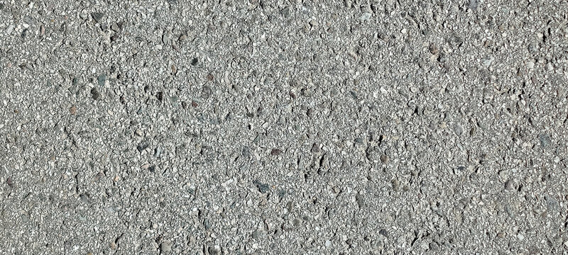 Primer plano de una superficie de asfalto gris con textura rugosa y peque&ntilde;os fragmentos minerales