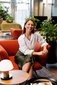 Portrait Smiling Woman Sitting in Office Lounge