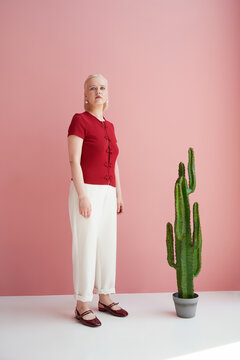 Woman in red top and white trousers with cactus
