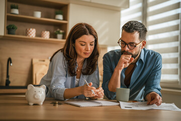 Couple managing home finances, budgeting expenses, and planning savings