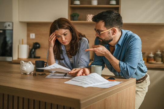 Stressed young couple managing bills and financial problems at home