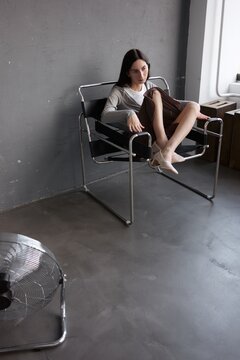 Portrait Woman Sit in Chair in Industrial Interior