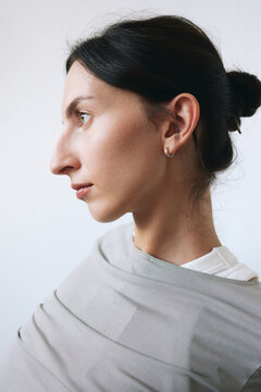 Profile portrait of woman in gray top studio background