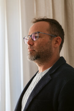 Thoughtful Man in Glasses Posing in a Bright Indoor Space