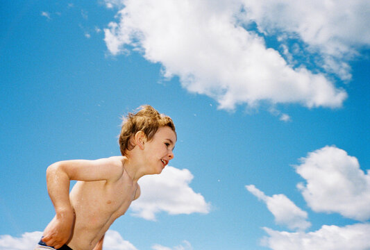 Child running on the beach against big blue sky