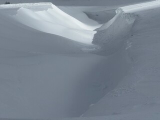 Snow cornice and deep drift in a minimalist winter mountain landscape with soft light © .shock
