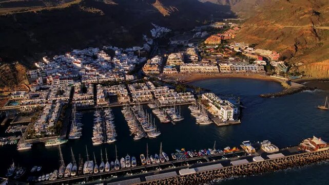 Sunset glow over the white houses and the marina in Puerto de Mogan