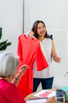 Fashion designers showing dress prototype to client during meeting