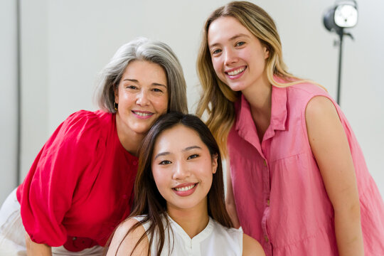 Three happy women of different ages and ethnicities smiling together