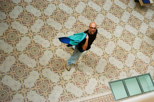 Top view over a man looking up in a large public room.