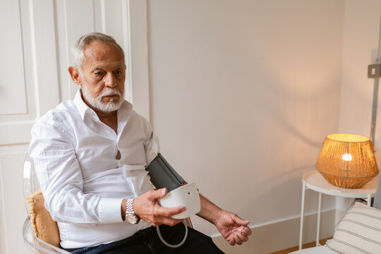 Senior Man Takes His Blood Pressure at Home During the Day