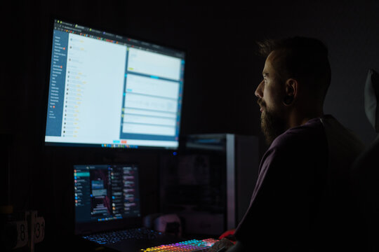 Bearded tattooed man working at night