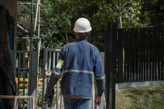 Construction worker walks towards building site in daylight hours